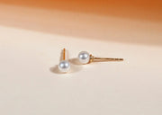 Women’s pearl stud earrings featuring classic round pearls set on delicate posts, offering a timeless and elegant accessory for any outfit.